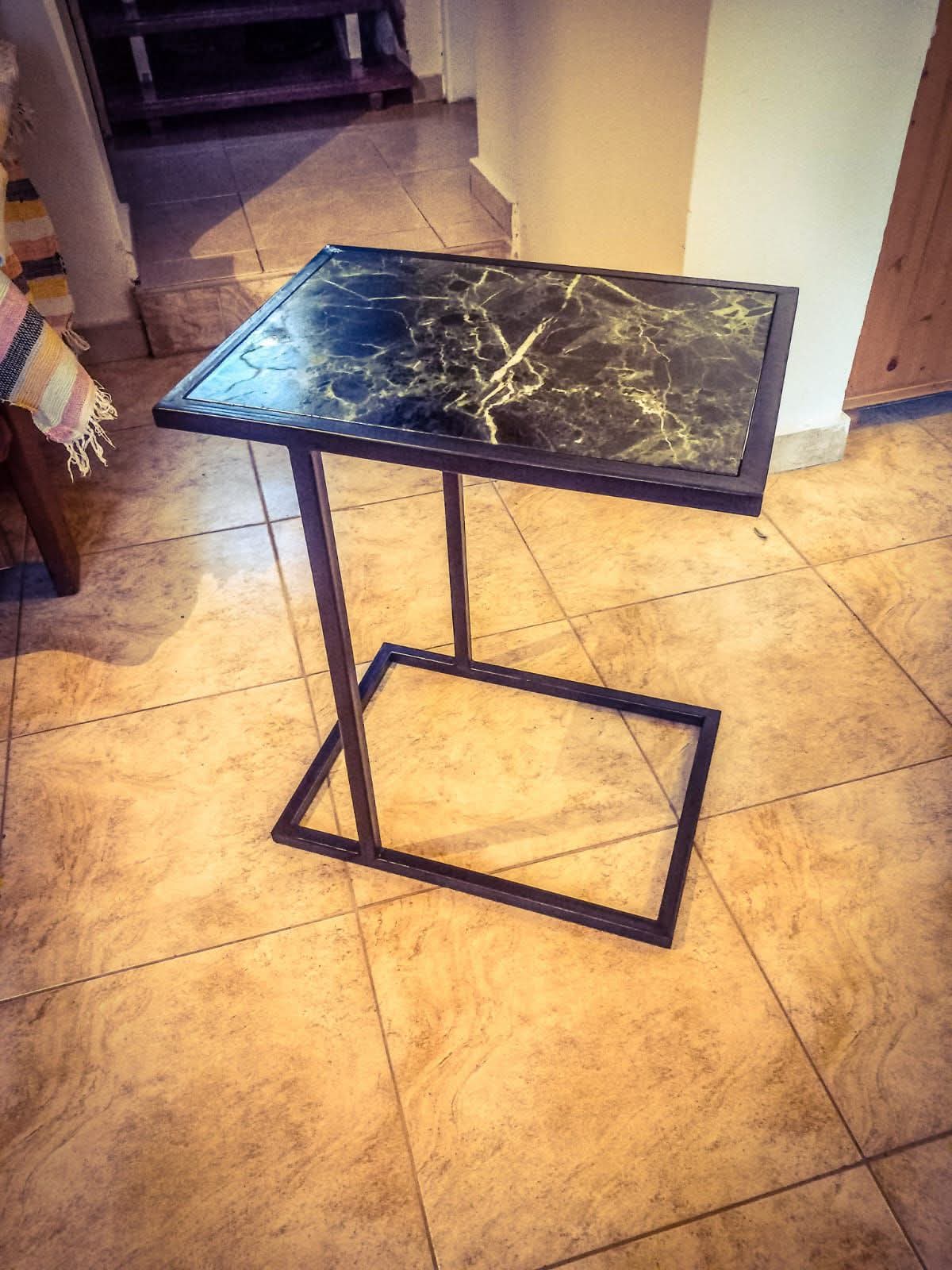 Cantilevered steel C-table with dark marble top