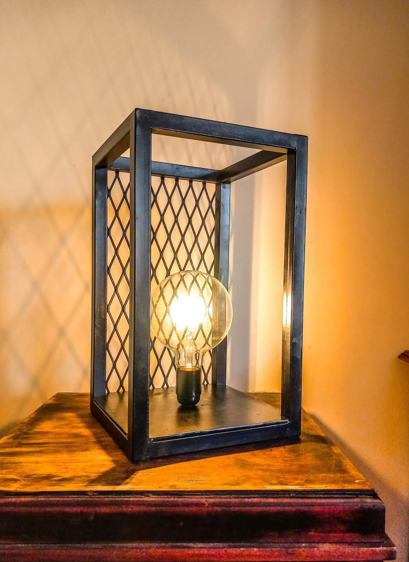 Handmade steel cage table lamp with mesh panels and filament bulb